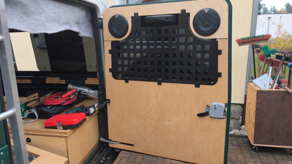 Finished tailgate trim panel with speakers and grit