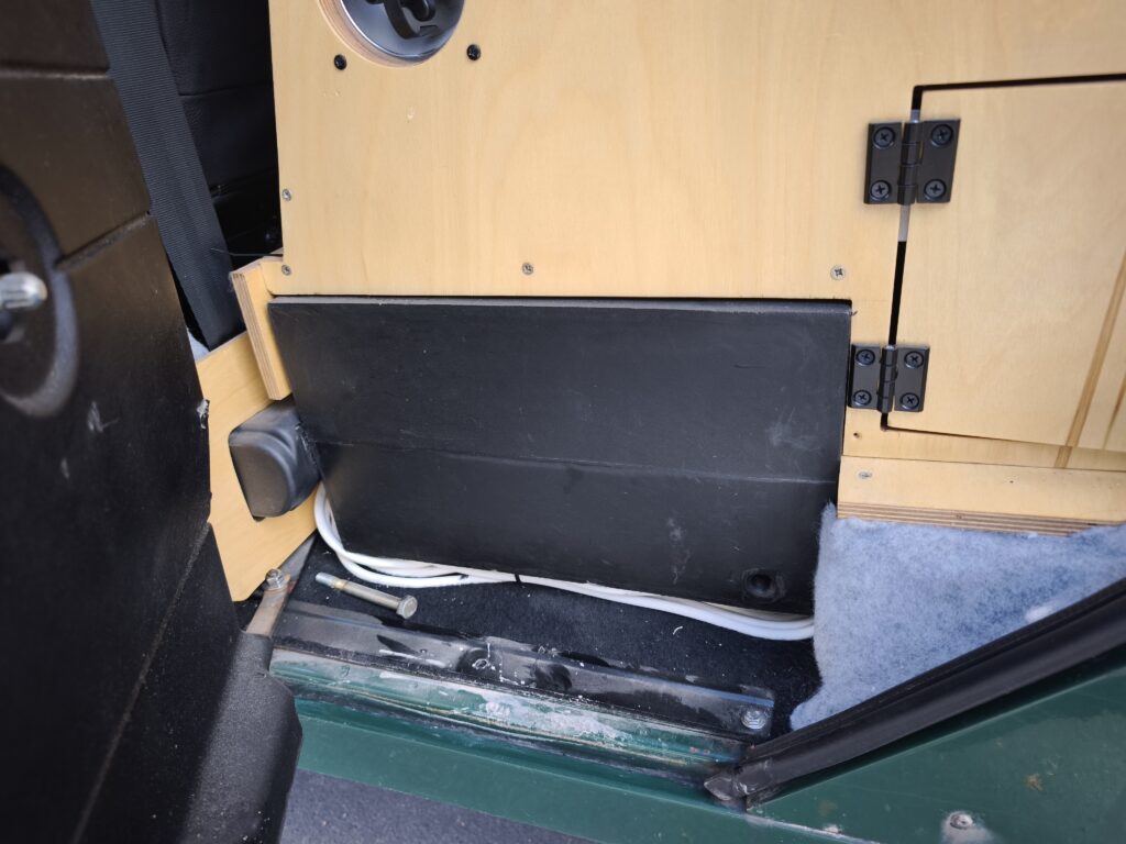 Placement of the water tank in the footwell of the backseat passengers