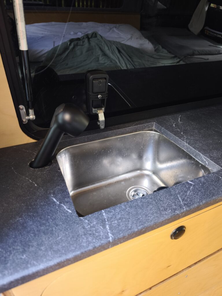 Mehr über den Artikel erfahren Wasserversorgung im Defender-Camper: 64-l-Tank, Pumpe & Dusche selbst einbauen